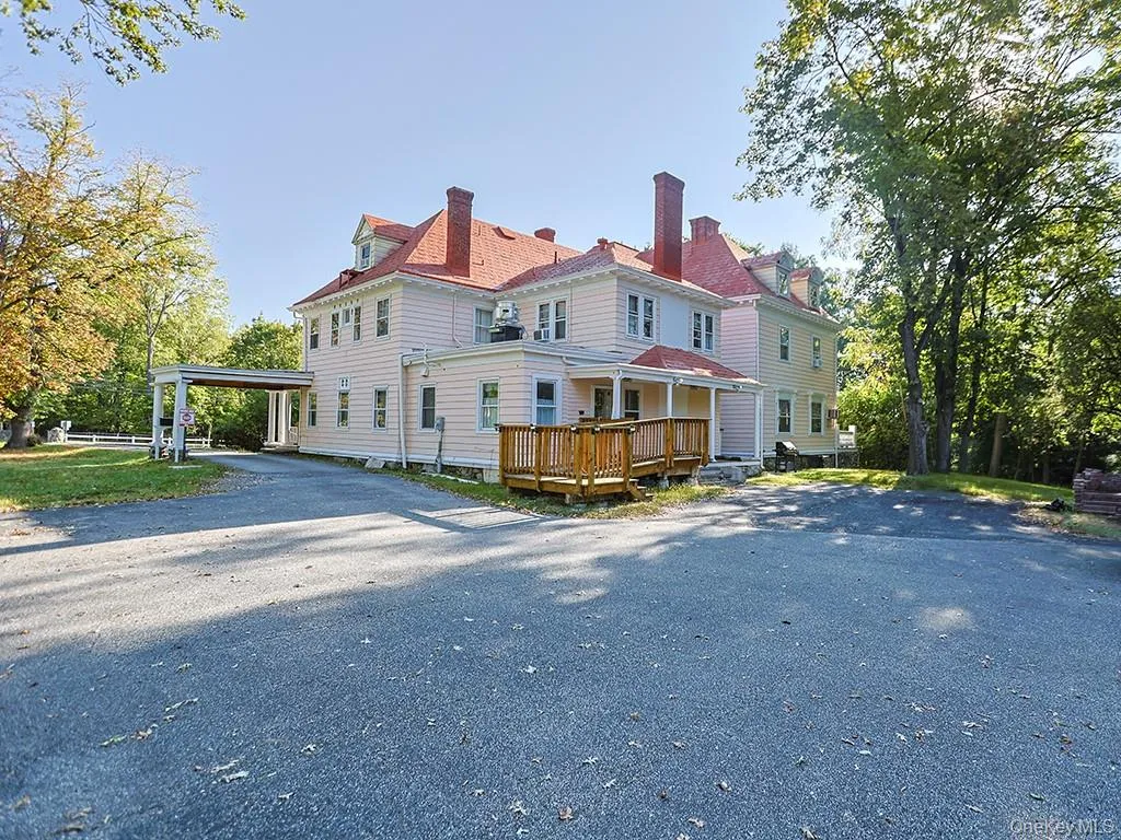 Back of property featuring a chimney, driveway, a carport, and a porch Back of property featuring a chimney, driveway, a carport, and a porch