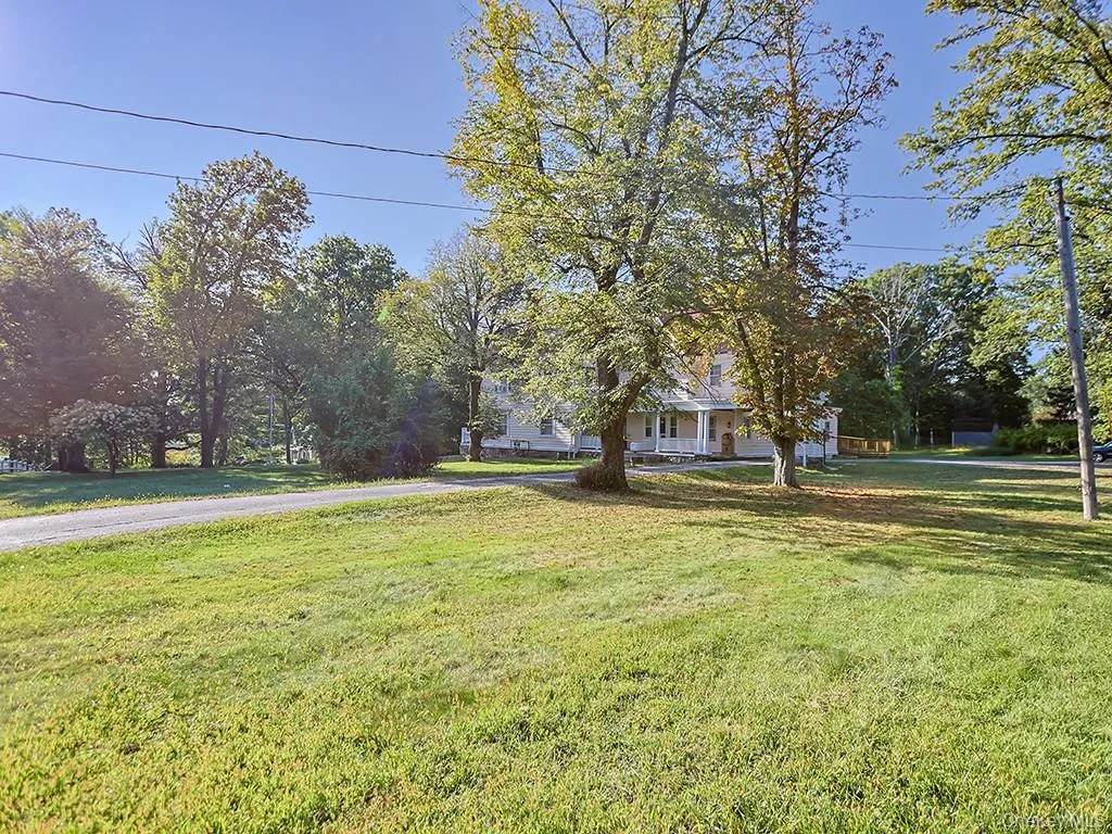 View of grassy yard featuring covered porch View of grassy yard featuring covered porch