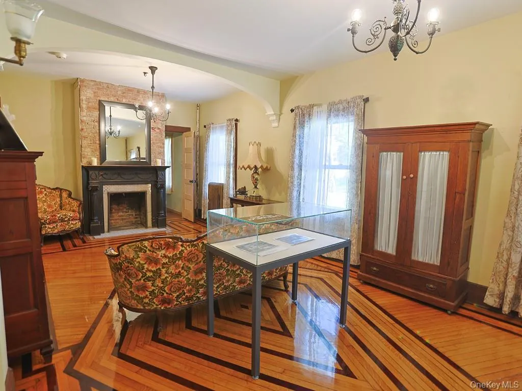 Dining space with a chandelier, a fireplace, wood finished floors, and arched walkways Dining space with a chandelier, a fireplace, wood finished floors, and arched walkways