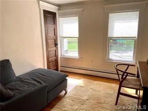 Living area with a baseboard heating unit and wood finished floors Living area with a baseboard heating unit and wood finished floors