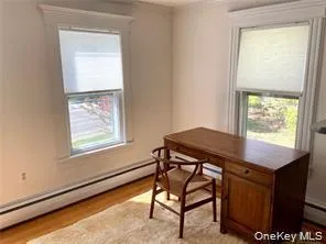 Home office with baseboard heating and light wood-style flooring Home office with baseboard heating and light wood-style flooring