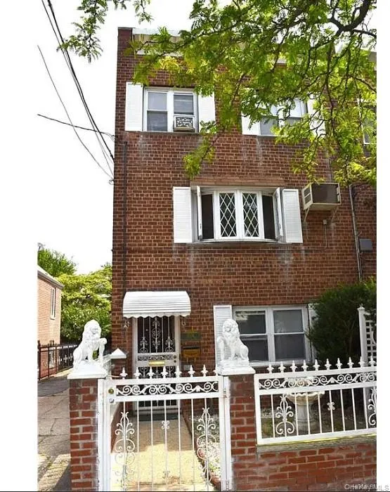 Rear view of property featuring a gate, brick siding, and a fenced front yard Rear view of property featuring a gate, brick siding, and a fenced front yard
