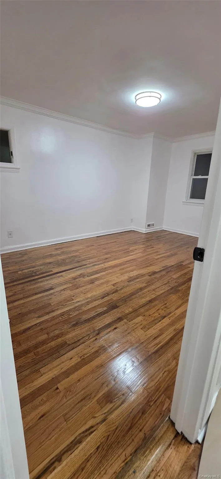 Unfurnished room with light wood-style floors and ornamental molding Unfurnished room with light wood-style floors and ornamental molding
