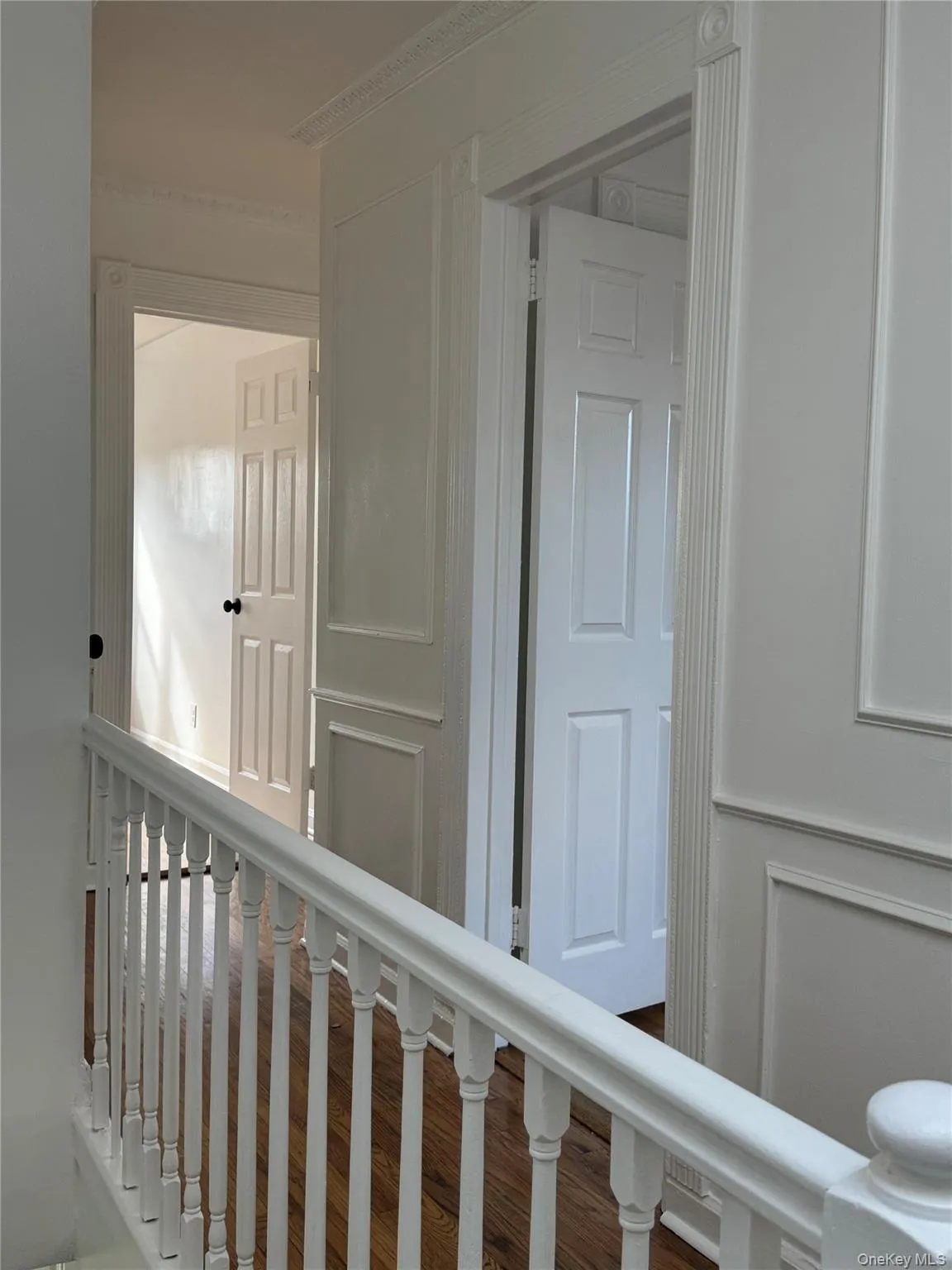 Hall featuring wood finished floors and an upstairs landing Hall featuring wood finished floors and an upstairs landing
