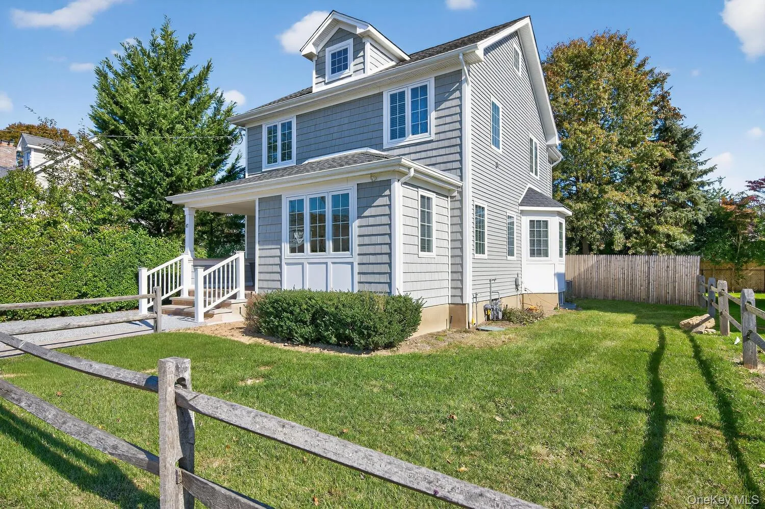 American foursquare style home with a fenced backyard, covered porch, and a shingled roof American foursquare style home with a fenced backyard, covered porch, and a shingled roof