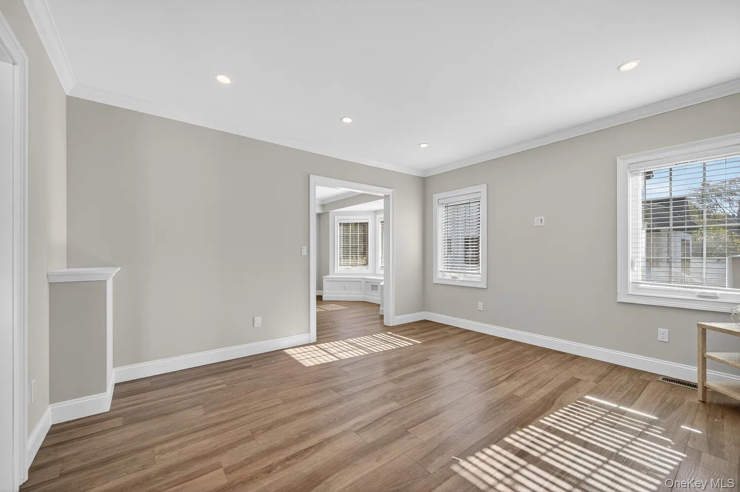 Empty room featuring crown molding, wood finished floors, and recessed lighting Empty room featuring crown molding, wood finished floors, and recessed lighting