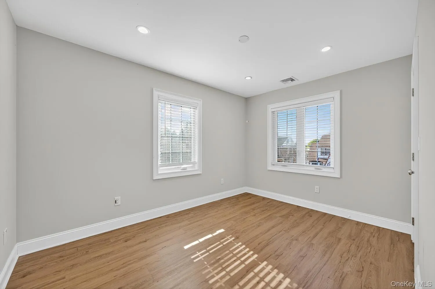 Spare room with wood finished floors and recessed lighting Spare room with wood finished floors and recessed lighting