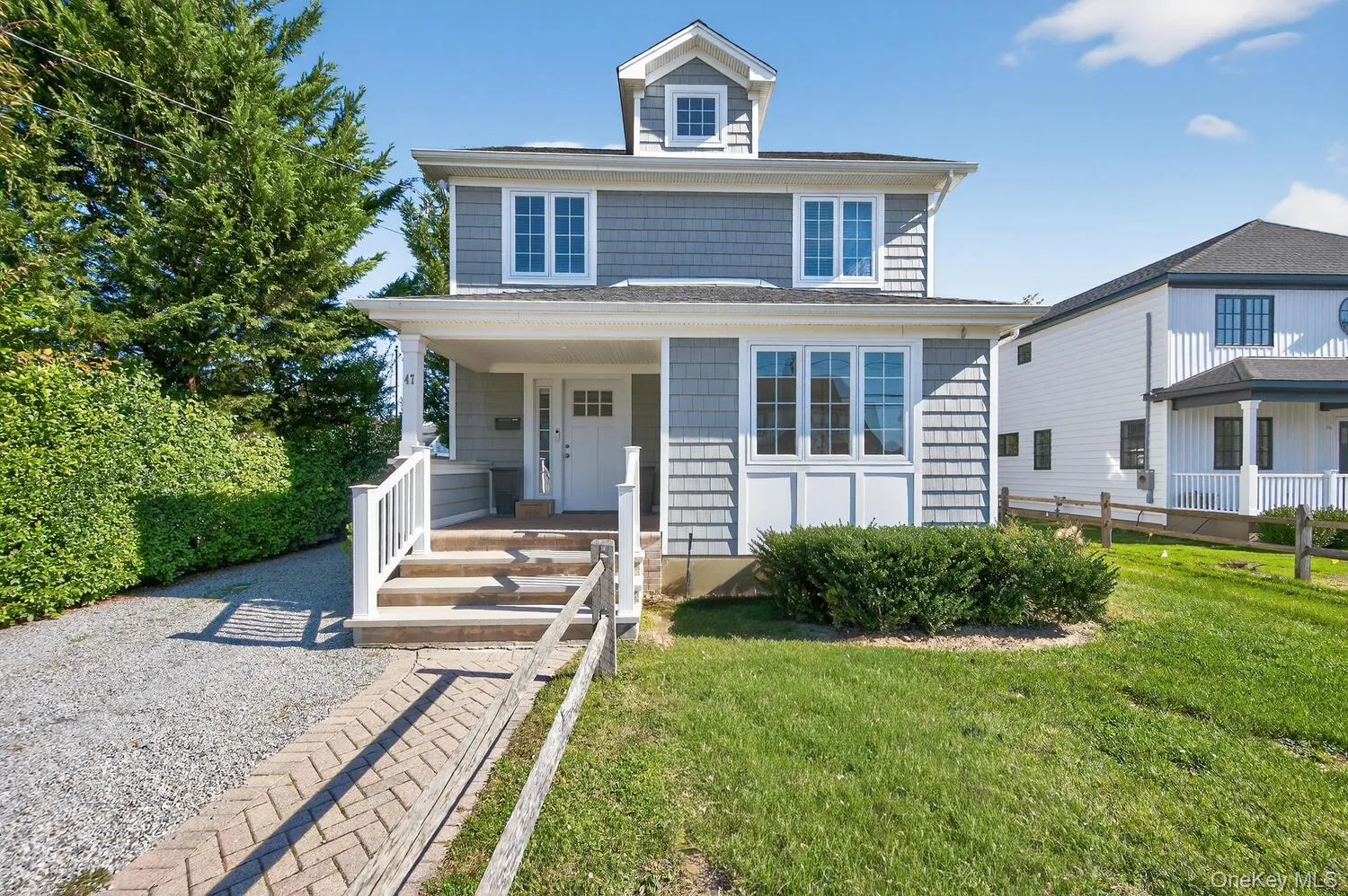 American foursquare style home featuring covered porch and a front lawn American foursquare style home featuring covered porch and a front lawn