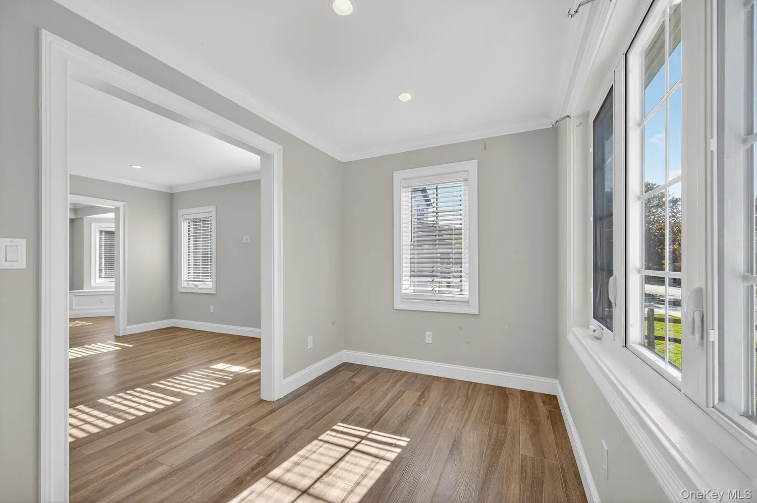 Spare room with crown molding, wood finished floors, and recessed lighting Spare room with crown molding, wood finished floors, and recessed lighting