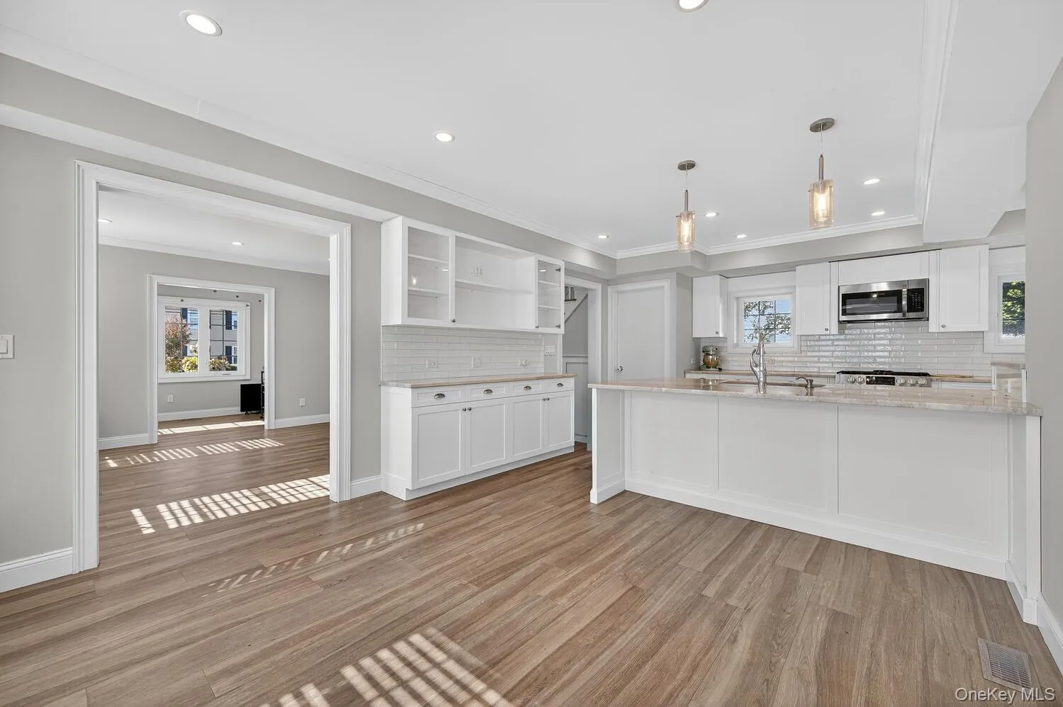 Kitchen with open shelves, white cabinets, healthy amount of natural light, recessed lighting, and ornamental molding Kitchen with open shelves, white cabinets, healthy amount of natural light, recessed lighting, and ornamental molding