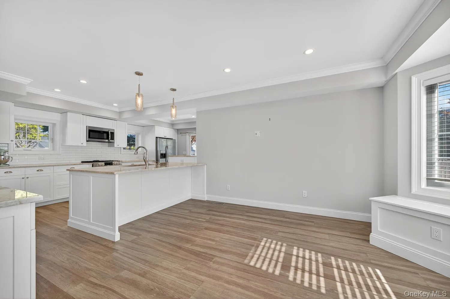 Kitchen featuring white cabinetry, decorative light fixtures, light stone counters, decorative backsplash, and recessed lighting Kitchen featuring white cabinetry, decorative light fixtures, light stone counters, decorative backsplash, and recessed lighting