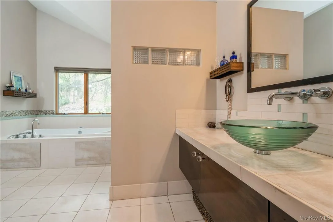 Amazing master bathroom in the main house. Vaulted ceilings, jetted tub with views of back yard, walk in shower, double vanity, lots of cabinetry and huge walk in closet. Amazing master bathroom in the main house. Vaulted ceilings, jetted tub with views of back yard, walk in shower, double vanity, lots of cabinetry and huge walk in closet.