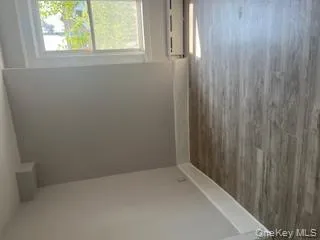 Spare room featuring wood finished floors and a baseboard radiator Spare room featuring wood finished floors and a baseboard radiator