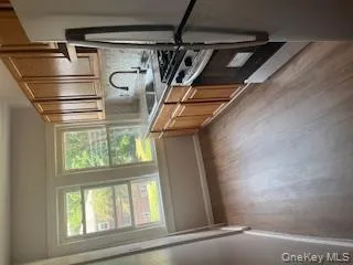 Kitchen featuring stove, fridge, dark wood-style flooring, light countertops, and tasteful backsplash Kitchen featuring stove, fridge, dark wood-style flooring, light countertops, and tasteful backsplash