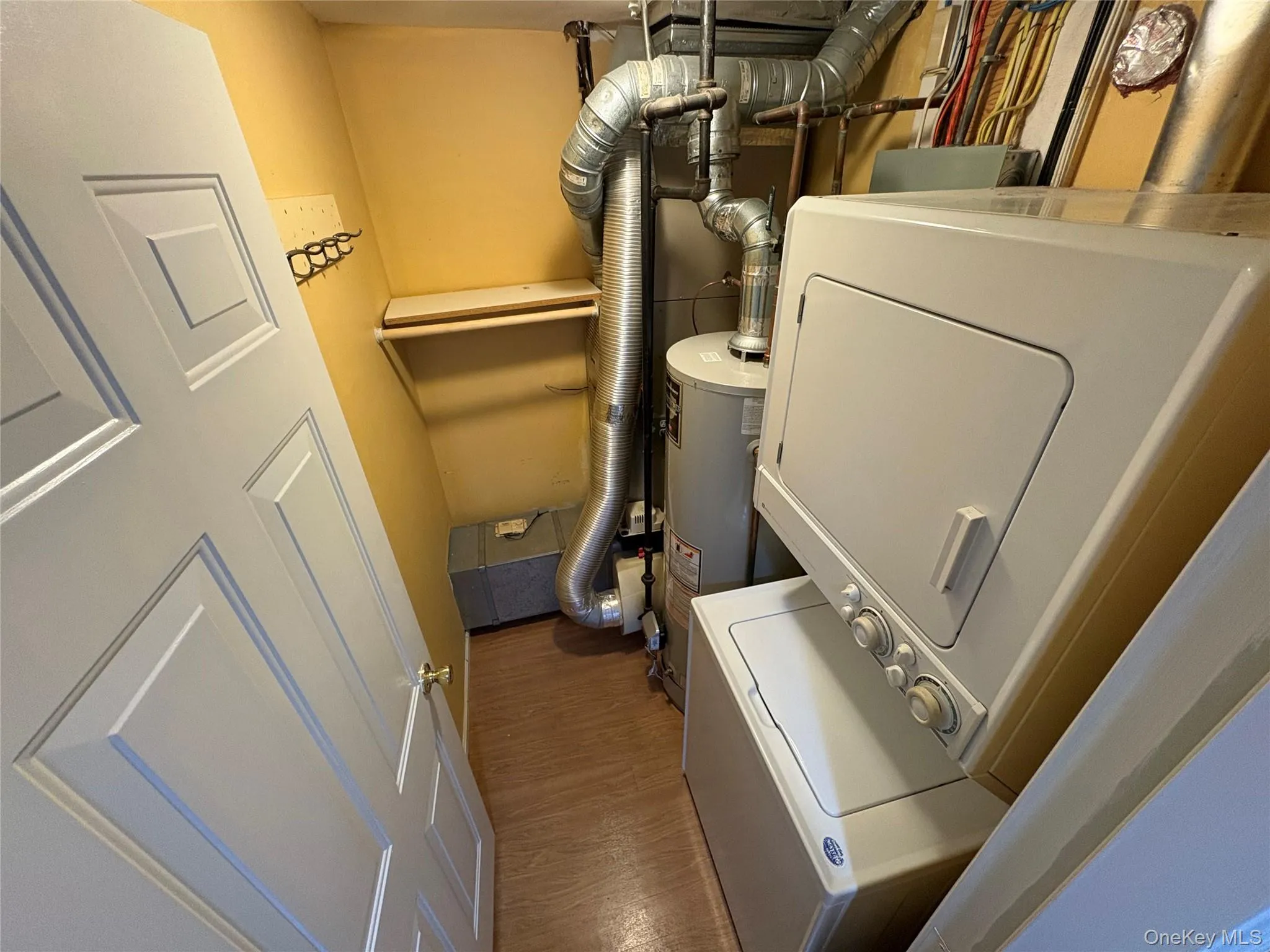 Washroom with washer / dryer, dark wood-style floors, and water heater Washroom with washer / dryer, dark wood-style floors, and water heater