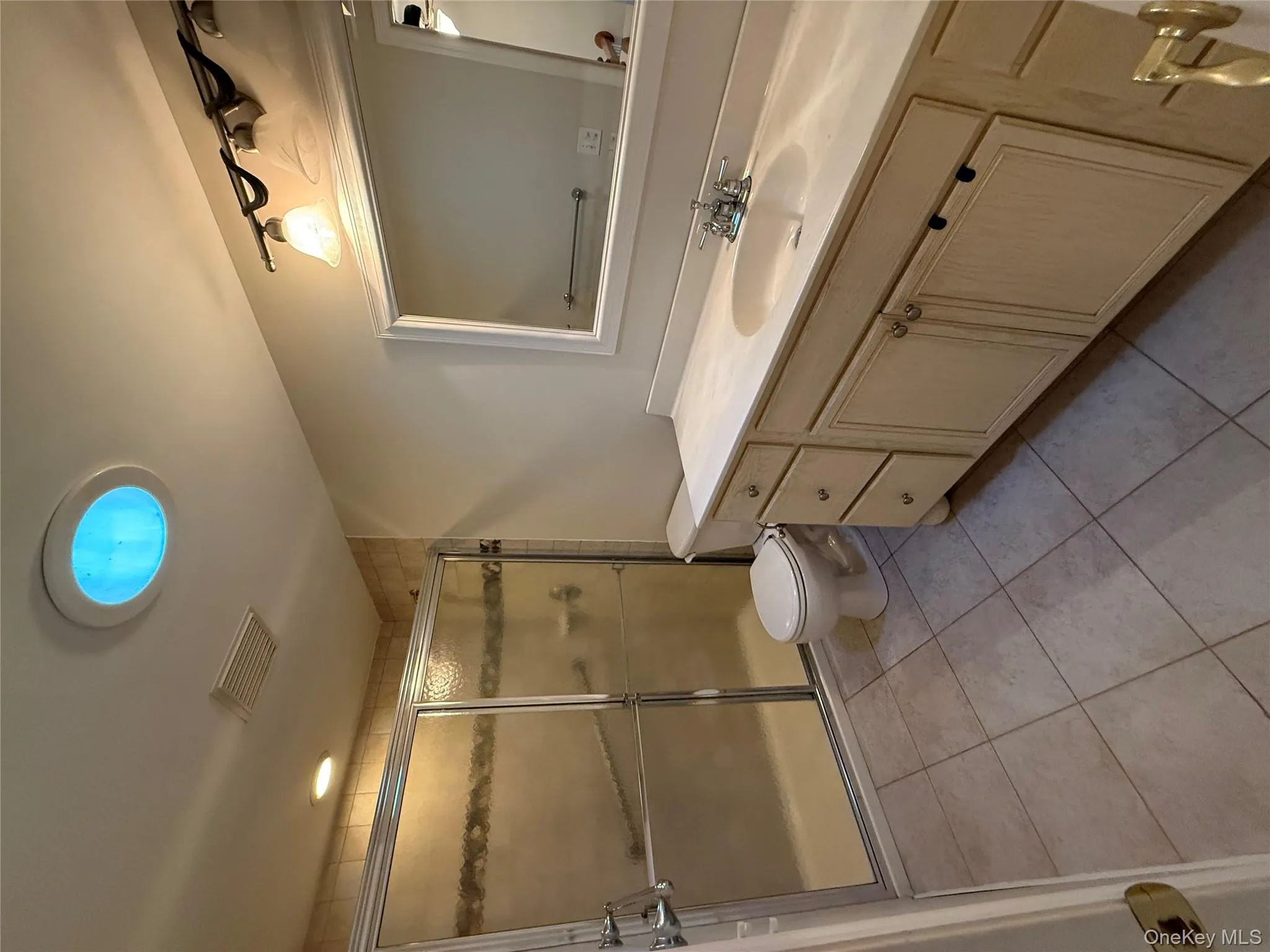 Full bath featuring vanity, light tile patterned floors, and a shower stall Full bath featuring vanity, light tile patterned floors, and a shower stall