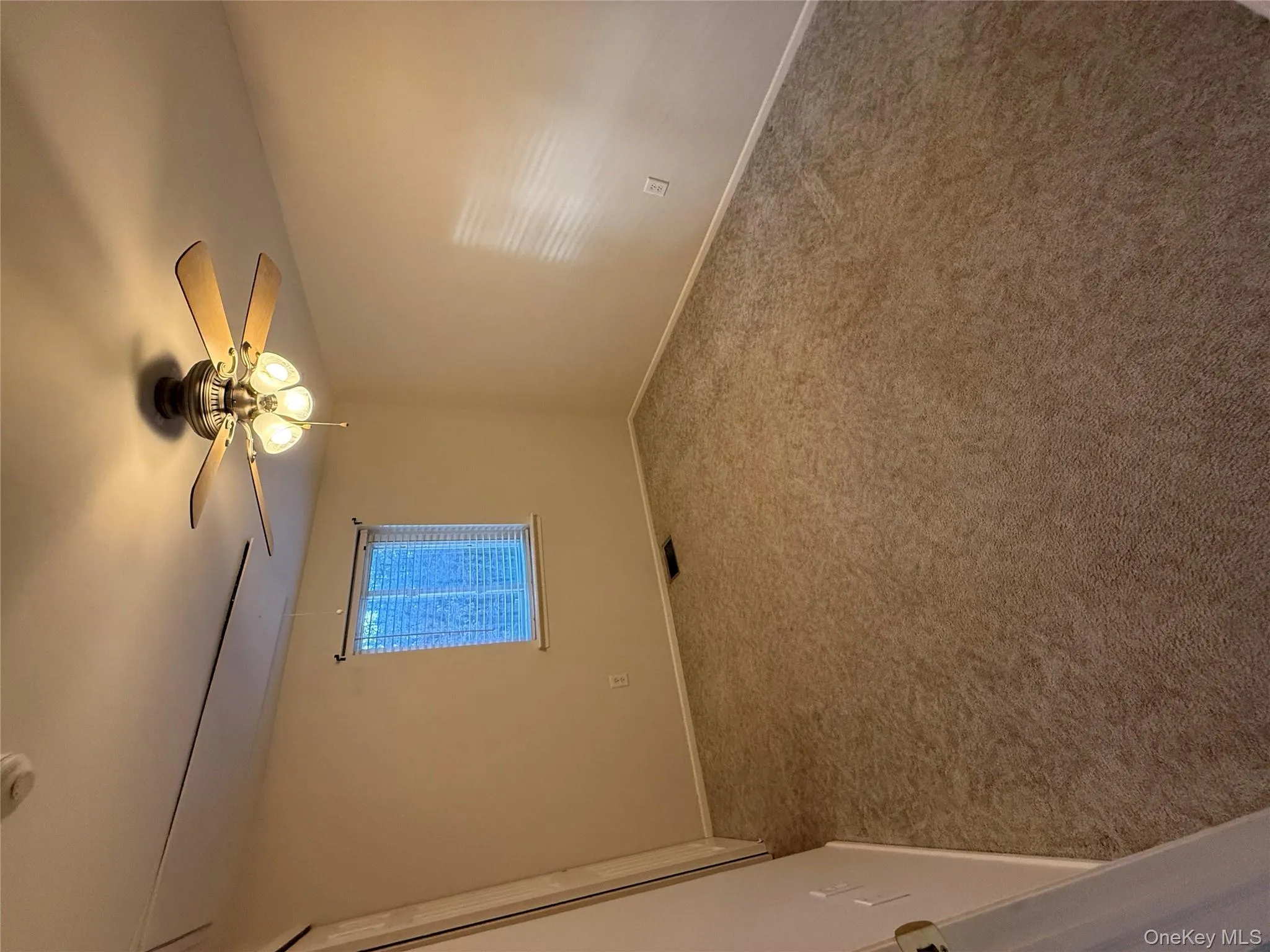 Carpeted spare room with baseboards and a smoke detector Carpeted spare room with baseboards and a smoke detector