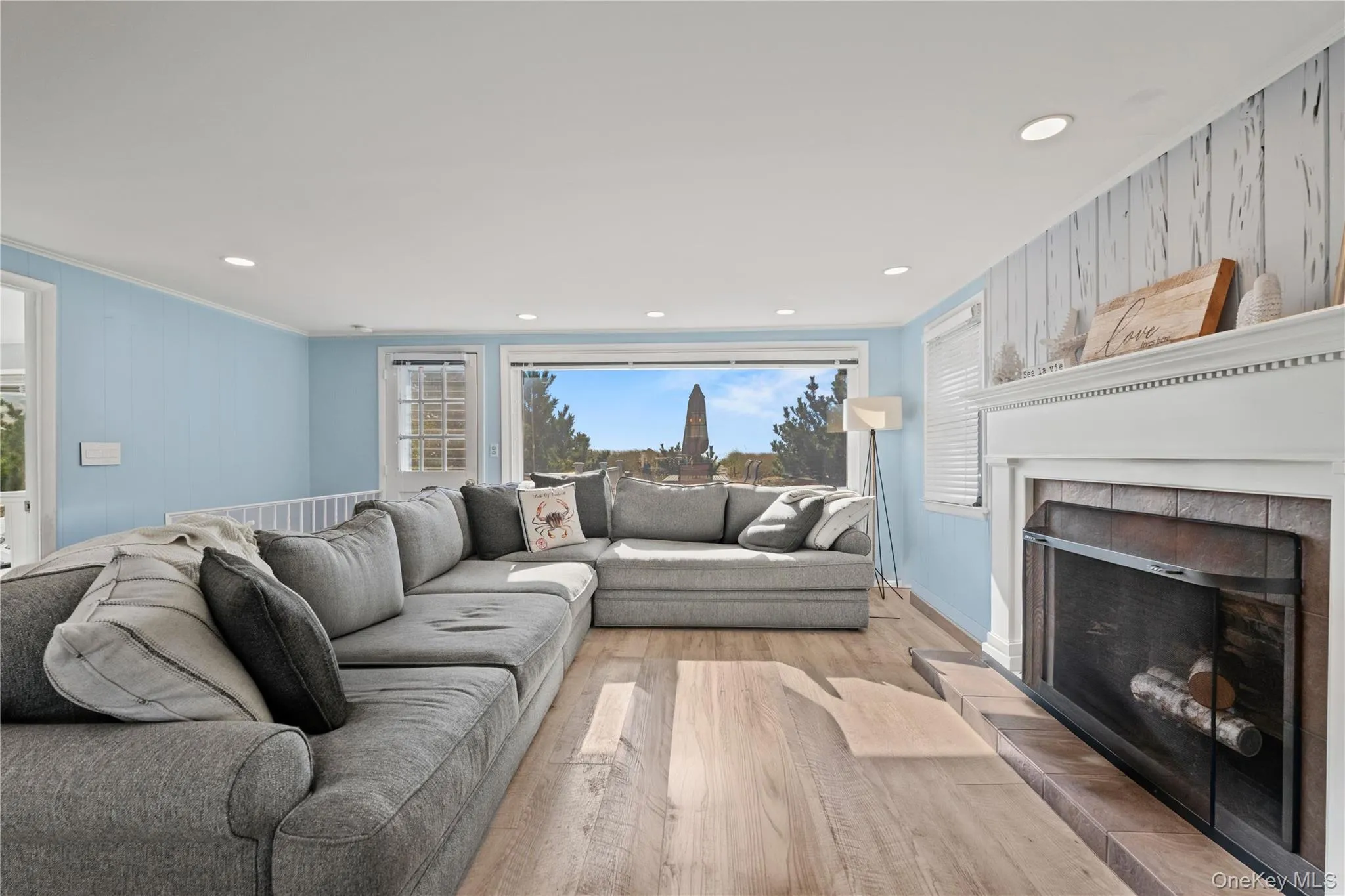Open Living room featuring crown molding, wood finished floors, a fireplace, recessed lighting, and wood walls Open Living room featuring crown molding, wood finished floors, a fireplace, recessed lighting, and wood walls