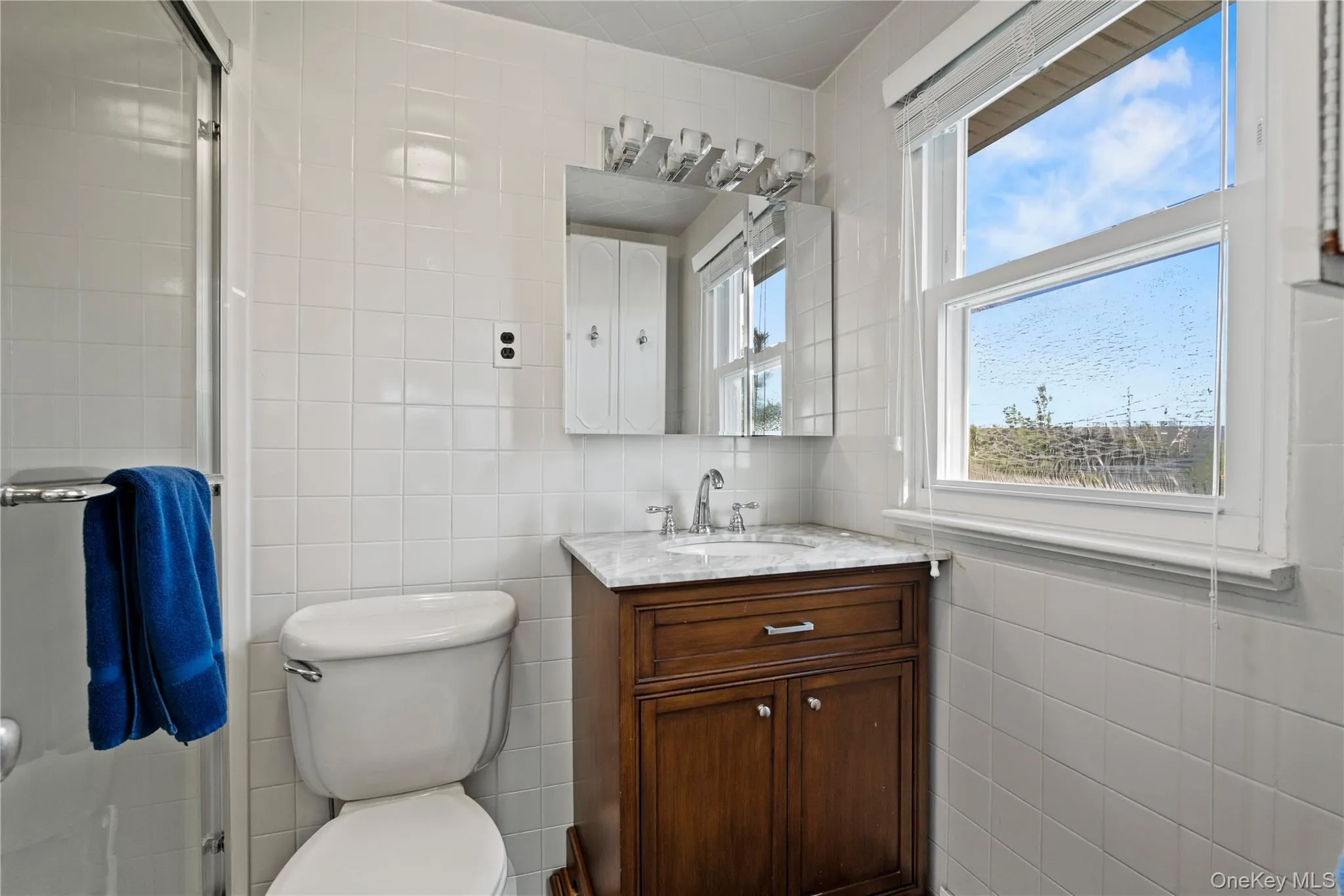 1of 3 Bathrooms featuring tile walls, vanity, and a stall shower 1of 3 Bathrooms featuring tile walls, vanity, and a stall shower