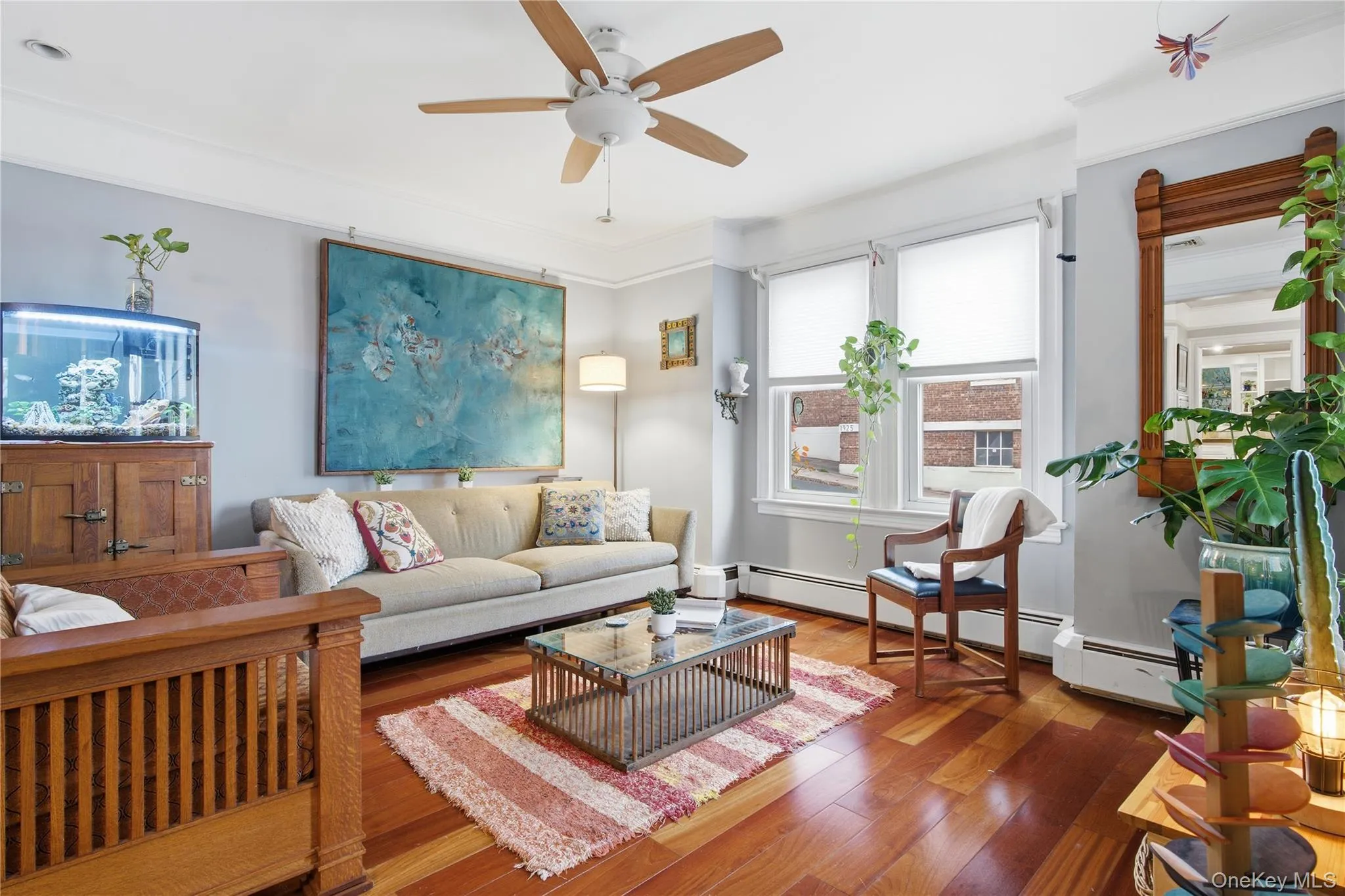 Living room featuring hardwood / wood-style flooring, ceiling fan, and crown molding Living room featuring hardwood / wood-style flooring, ceiling fan, and crown molding