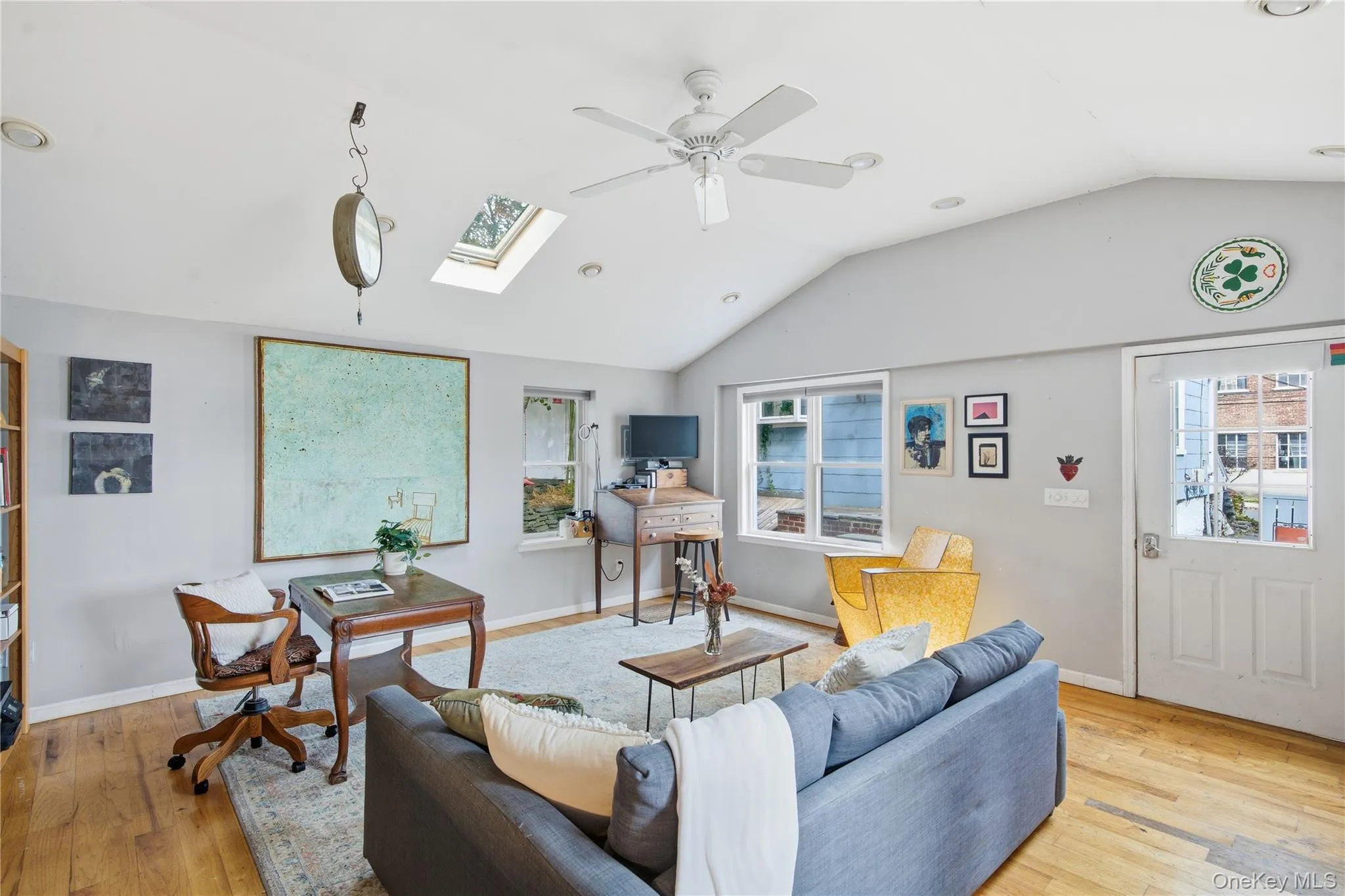 Living room with lofted ceiling, light wood finished floors, a skylight, recessed lighting, and healthy amount of natural light Living room with lofted ceiling, light wood finished floors, a skylight, recessed lighting, and healthy amount of natural light