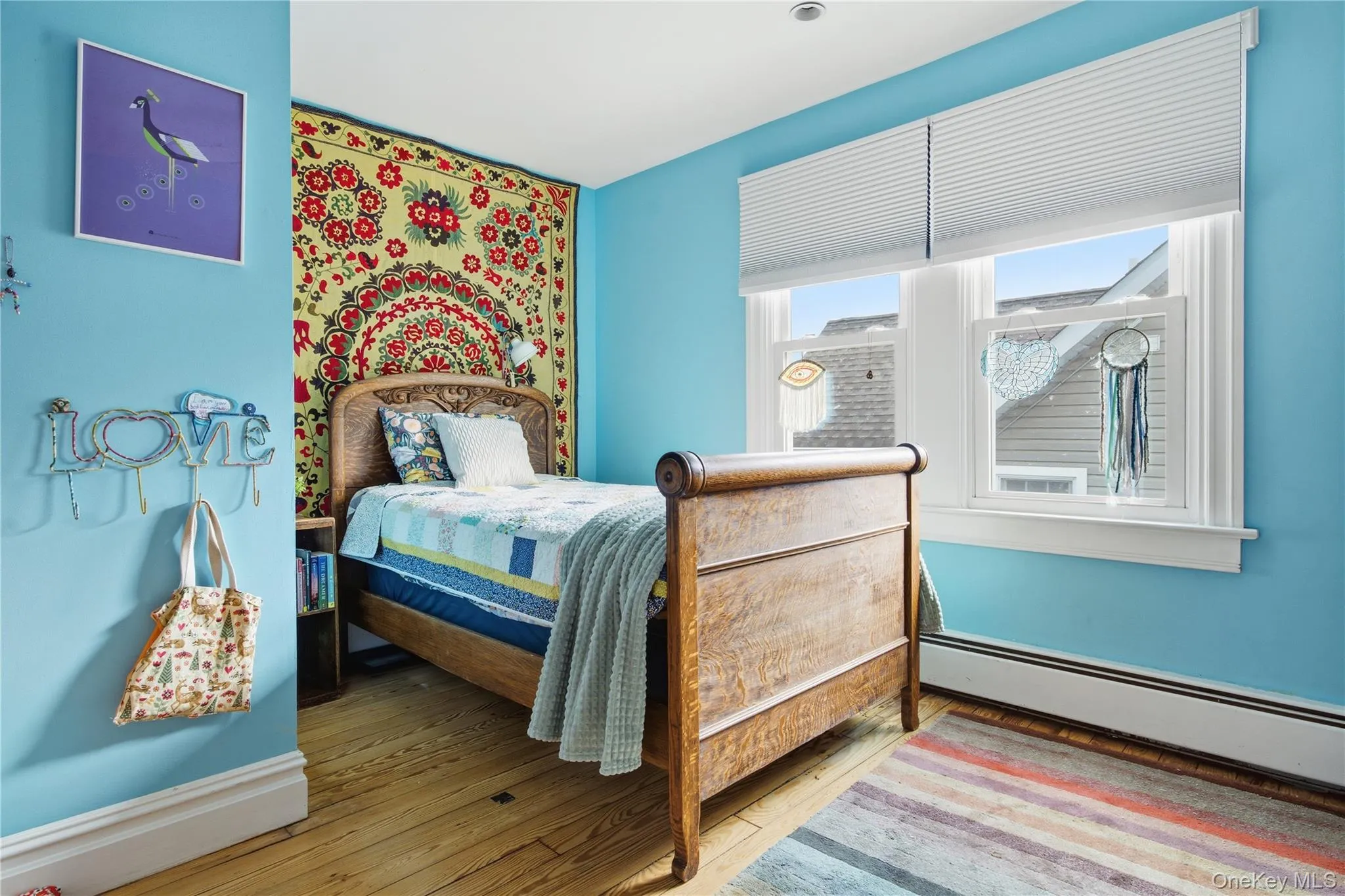 Bedroom featuring hardwood / wood-style flooring and a baseboard radiator Bedroom featuring hardwood / wood-style flooring and a baseboard radiator