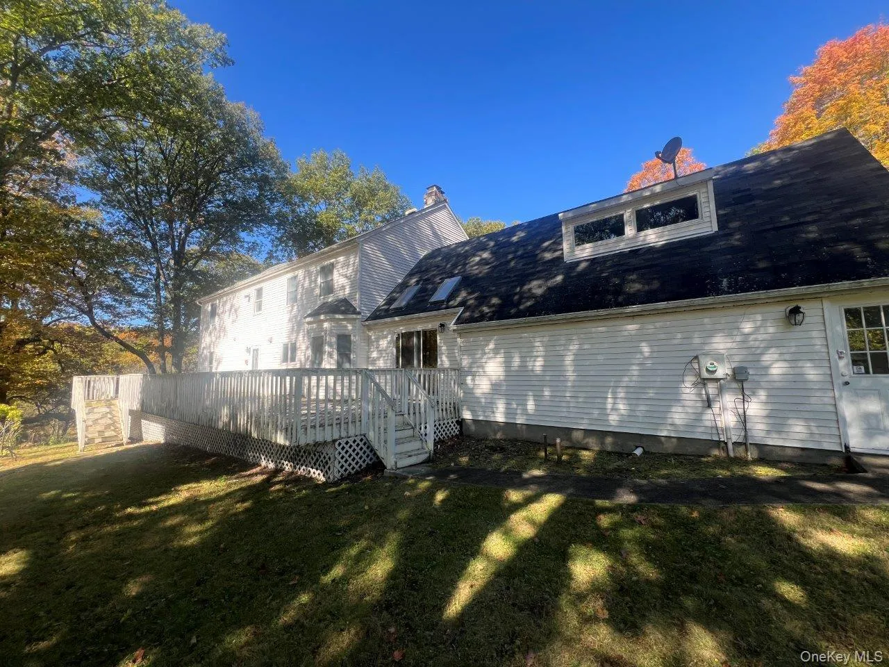 Back of property featuring a yard and a wooden deck Back of property featuring a yard and a wooden deck