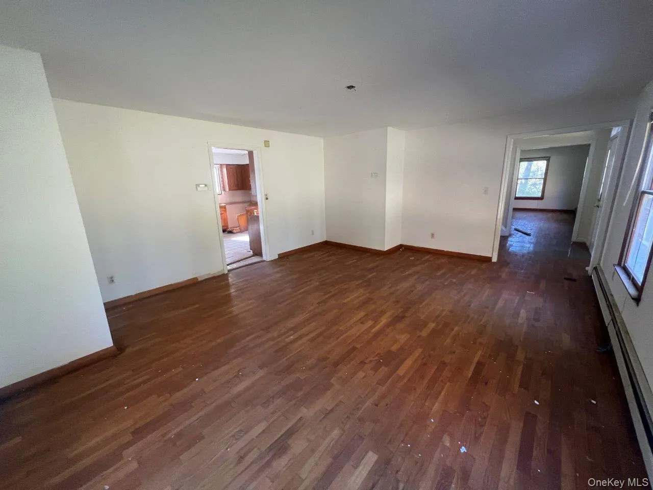 Spare room with baseboard heating and dark wood-style flooring Spare room with baseboard heating and dark wood-style flooring
