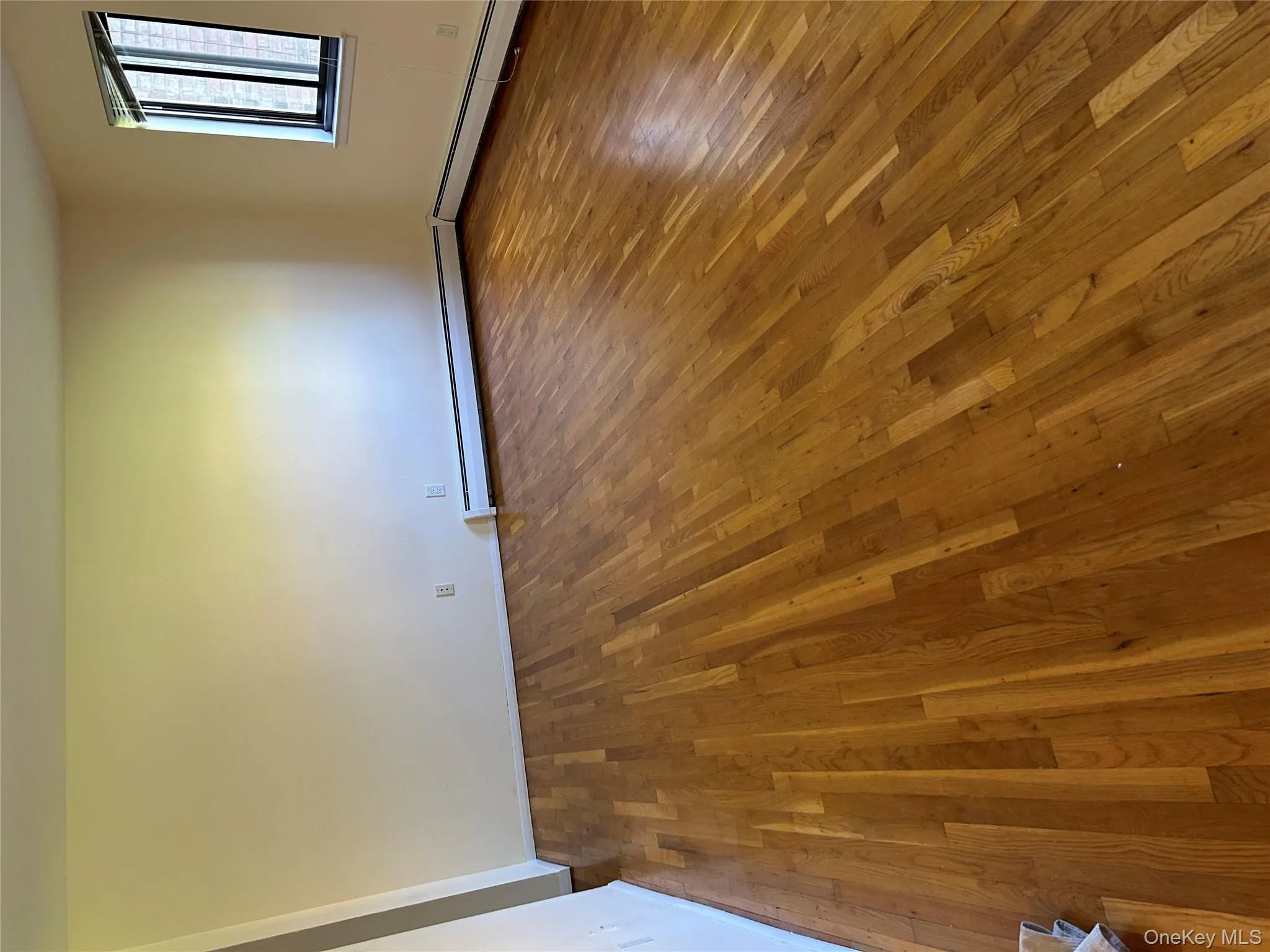 Unfurnished room featuring dark wood-style flooring and a baseboard heating unit Unfurnished room featuring dark wood-style flooring and a baseboard heating unit