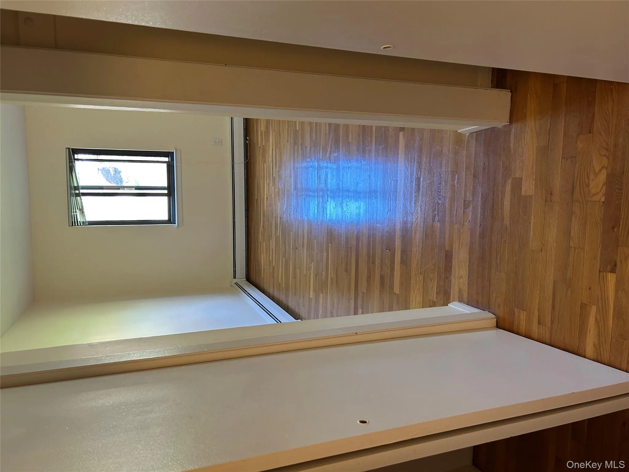 Hall with wood finished floors, a baseboard radiator, and a baseboard heating unit Hall with wood finished floors, a baseboard radiator, and a baseboard heating unit