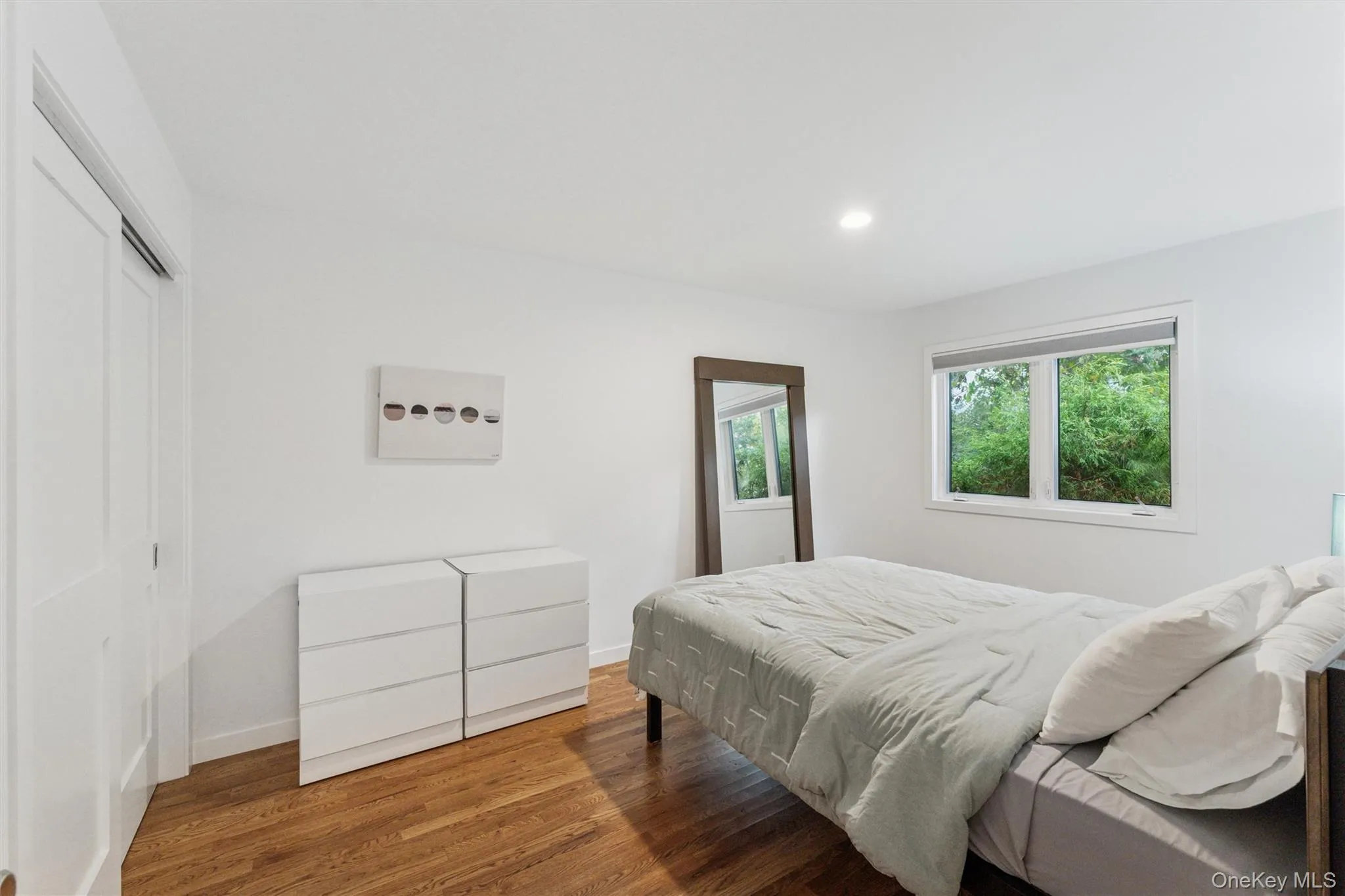 Bedroom with wood finished floors, recessed lighting, and a closet Bedroom with wood finished floors, recessed lighting, and a closet