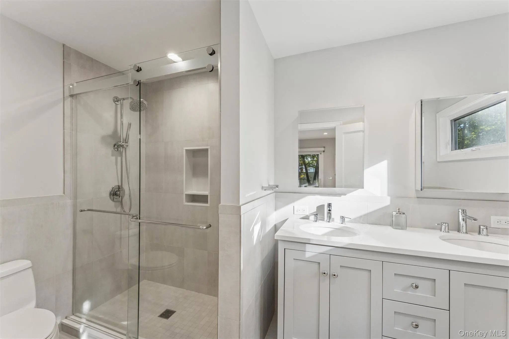 Bathroom with double vanity and a shower stall Bathroom with double vanity and a shower stall