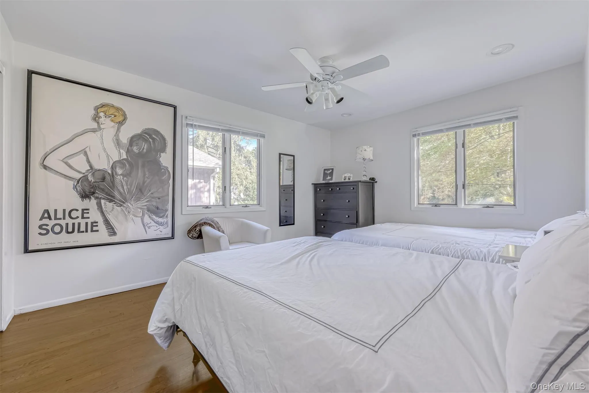 Bedroom with wood finished floors, multiple windows, and a ceiling fan Bedroom with wood finished floors, multiple windows, and a ceiling fan