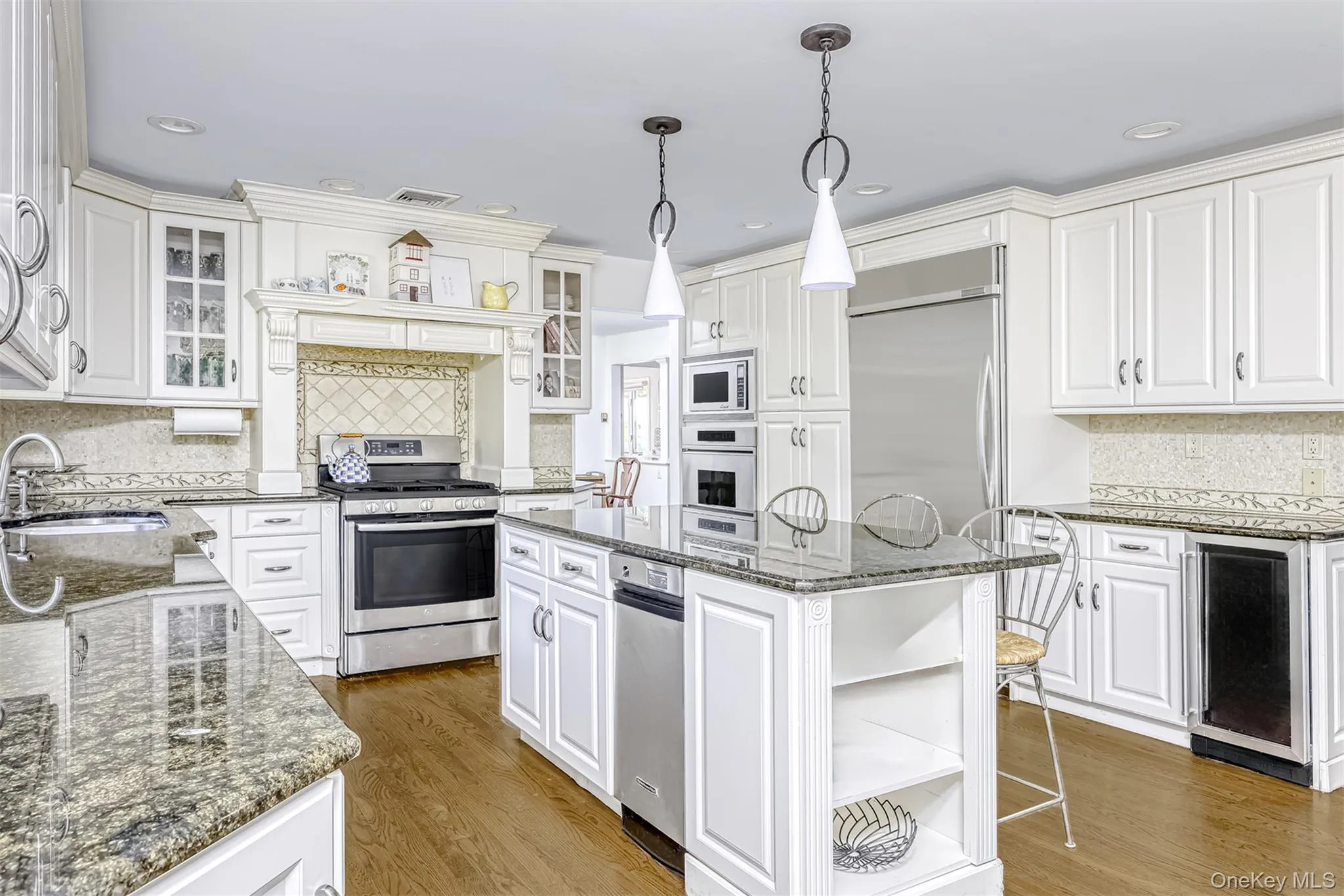 Kitchen featuring tasteful backsplash, open shelves, dark stone countertops, white cabinetry, and recessed lighting Kitchen featuring tasteful backsplash, open shelves, dark stone countertops, white cabinetry, and recessed lighting