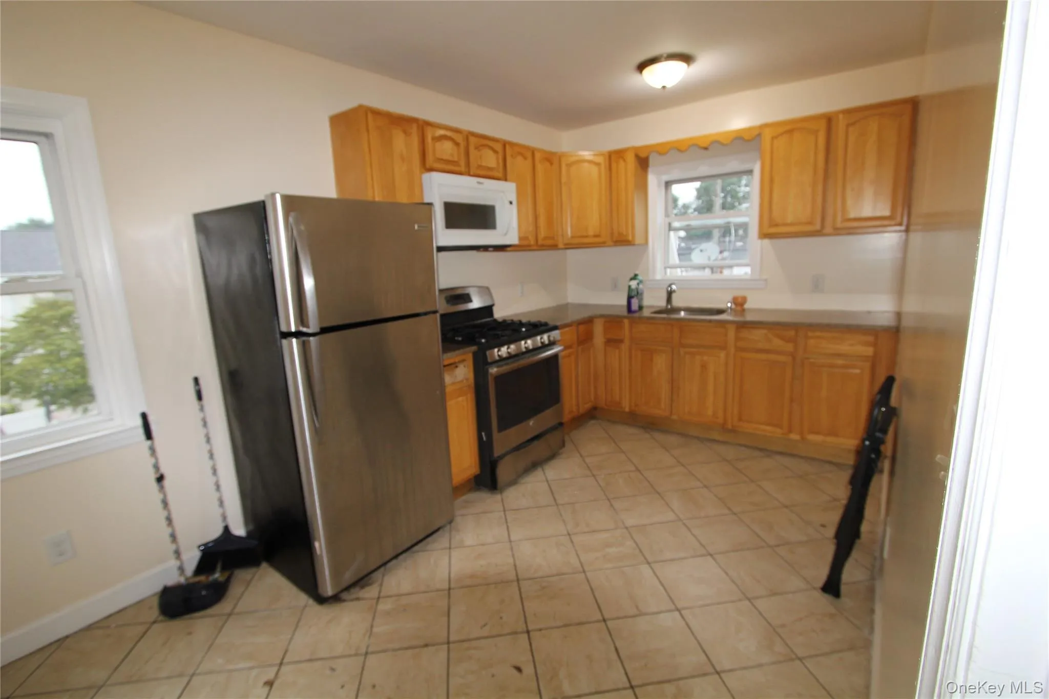 Kitchen featuring stainless steel appliances and light tile patterned flooring Kitchen featuring stainless steel appliances and light tile patterned flooring