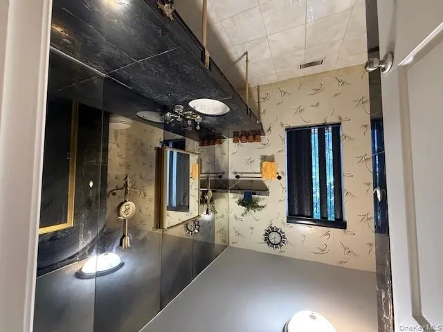 Bathroom with wallpapered walls, vanity, and light tile patterned floors Bathroom with wallpapered walls, vanity, and light tile patterned floors