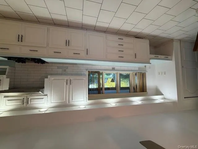 Kitchen featuring tasteful backsplash, light countertops, and cooktop Kitchen featuring tasteful backsplash, light countertops, and cooktop