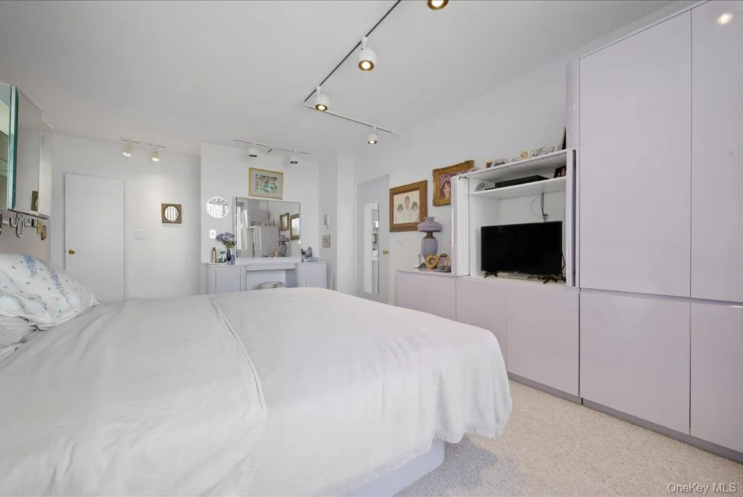 Bedroom with light carpet and rail lighting Bedroom with light carpet and rail lighting