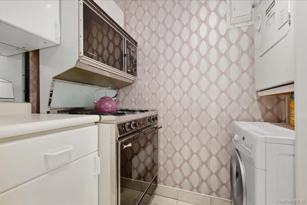 Laundry area with light tile patterned floors Laundry area with light tile patterned floors