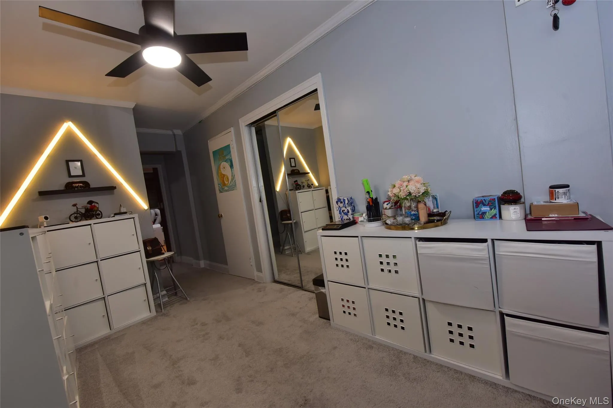 Bedroom featuring light colored carpet, crown molding, a ceiling fan, and a closet Bedroom featuring light colored carpet, crown molding, a ceiling fan, and a closet