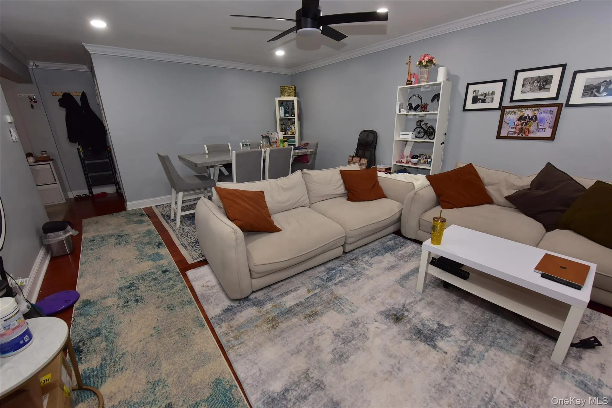 Living area with ornamental molding, recessed lighting, wood finished floors, ceiling fan, and a desk Living area with ornamental molding, recessed lighting, wood finished floors, ceiling fan, and a desk