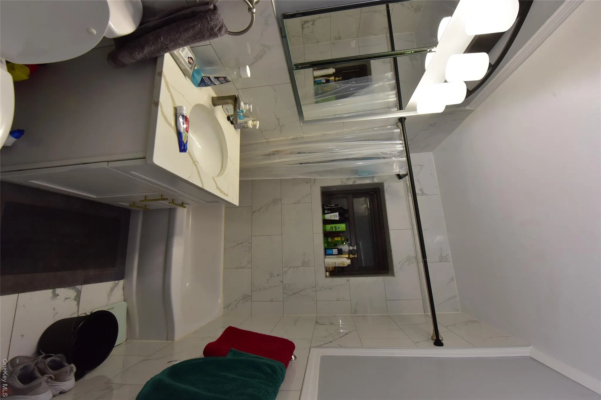 Bathroom with tile walls, vanity, shower / bathtub combination with curtain, and tasteful backsplash Bathroom with tile walls, vanity, shower / bathtub combination with curtain, and tasteful backsplash