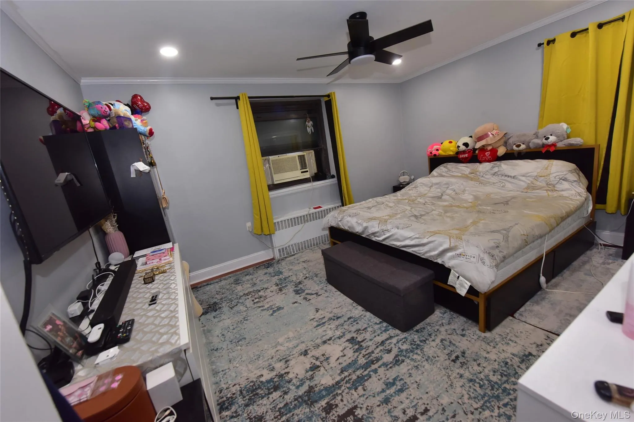 Bedroom featuring crown molding, radiator, ceiling fan, and recessed lighting Bedroom featuring crown molding, radiator, ceiling fan, and recessed lighting