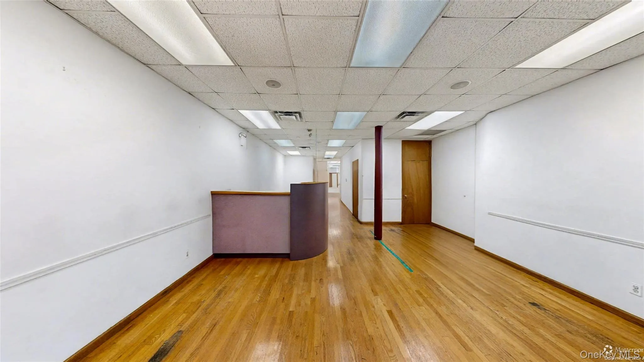 Unfurnished room featuring light wood-style flooring and a drop ceiling Unfurnished room featuring light wood-style flooring and a drop ceiling