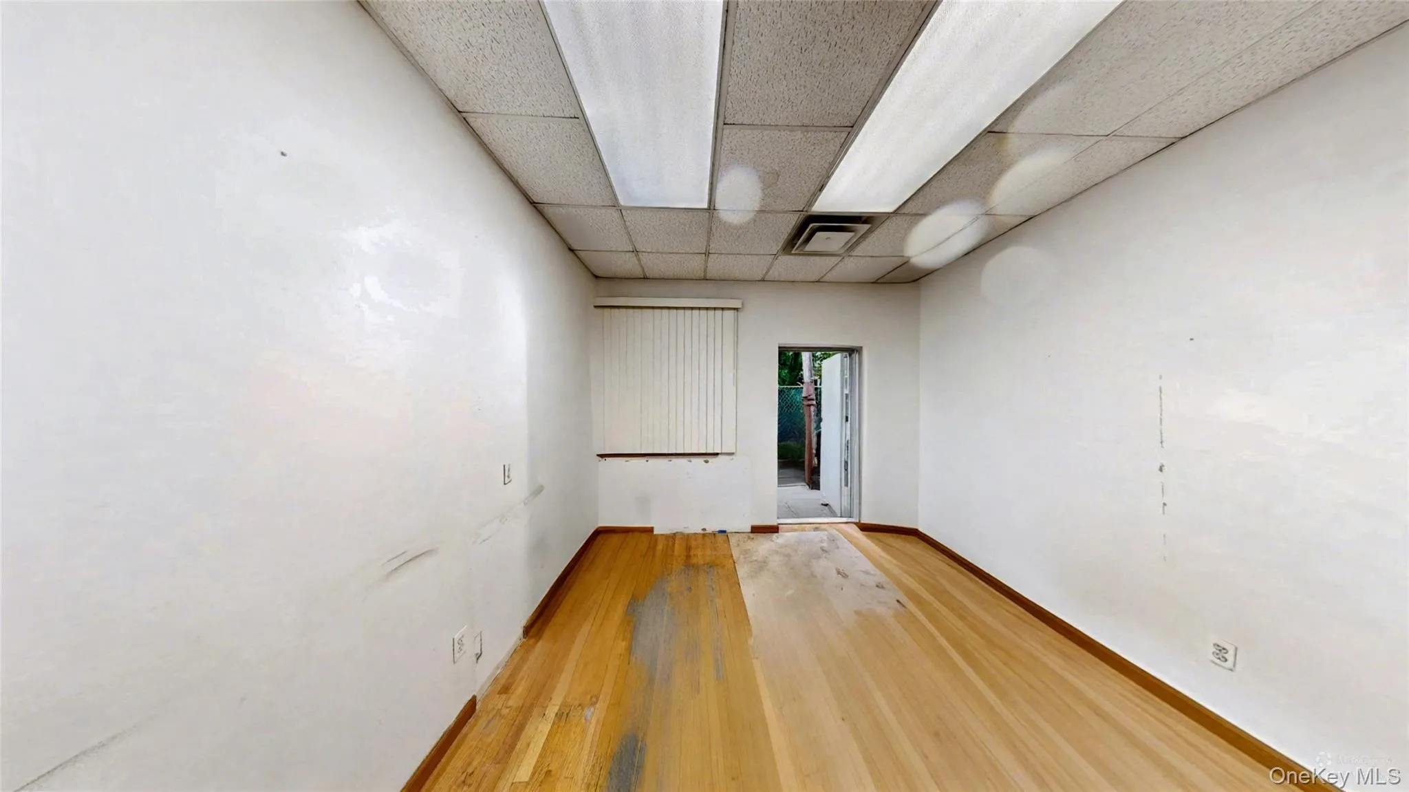 Spare room with light wood-type flooring and a drop ceiling Spare room with light wood-type flooring and a drop ceiling