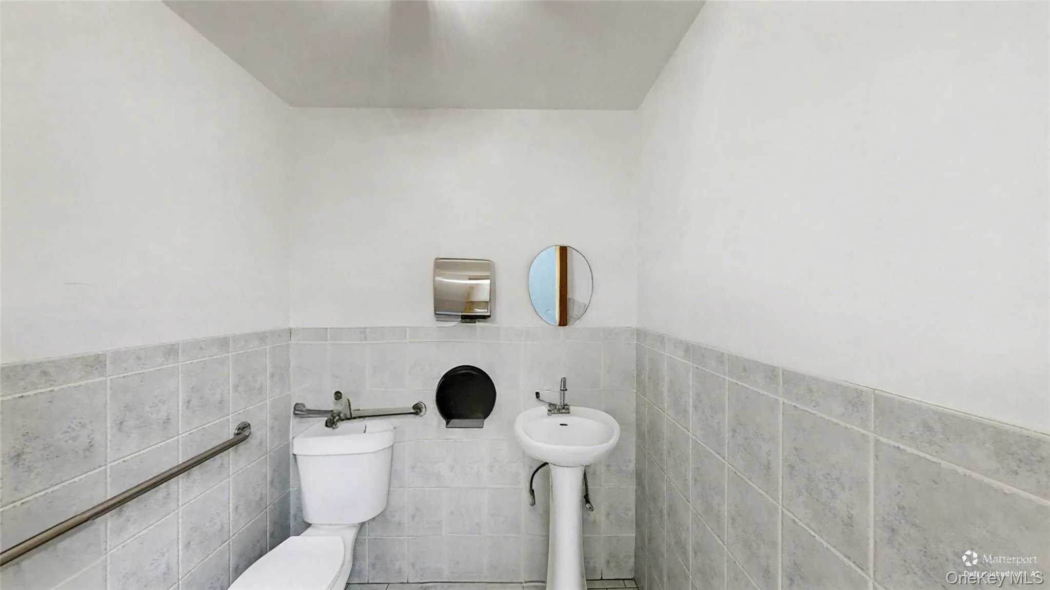 Bathroom with tile walls and a wainscoted wall Bathroom with tile walls and a wainscoted wall