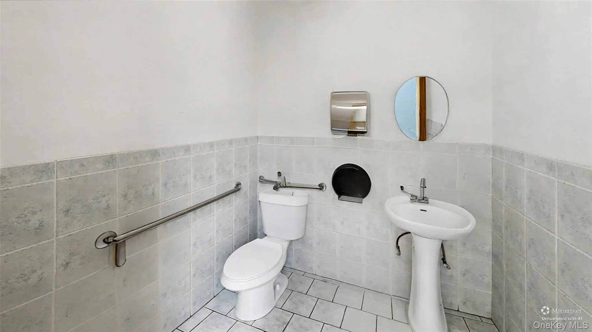 Half bath with tile patterned floors, a wainscoted wall, and tile walls Half bath with tile patterned floors, a wainscoted wall, and tile walls