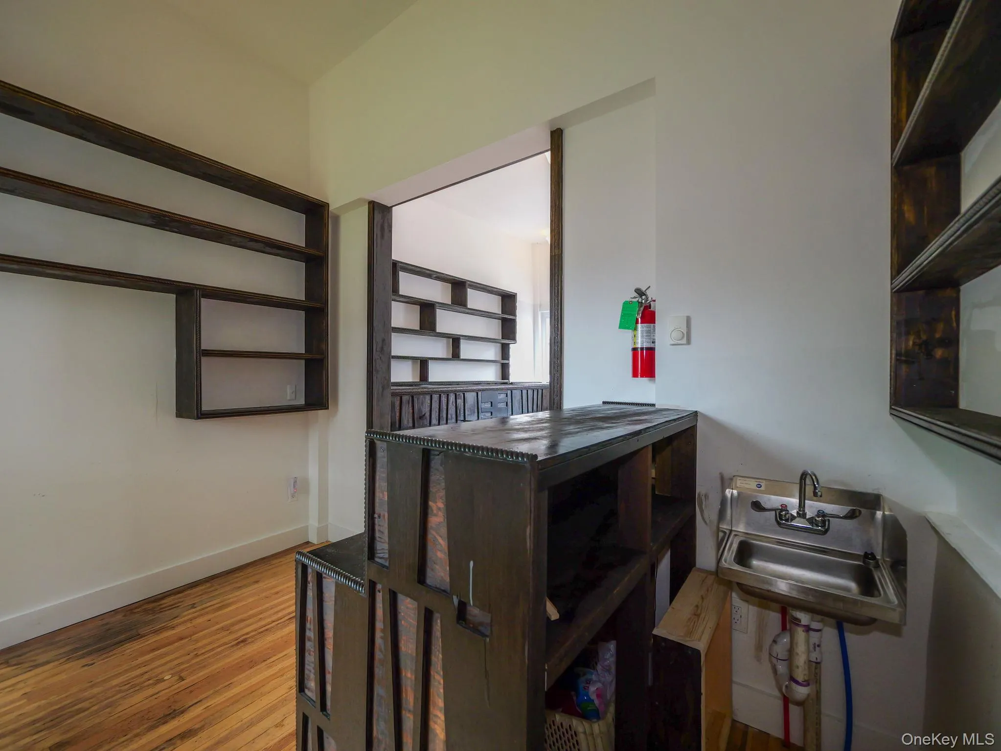 Bar featuring wood finished floors and baseboards Bar featuring wood finished floors and baseboards