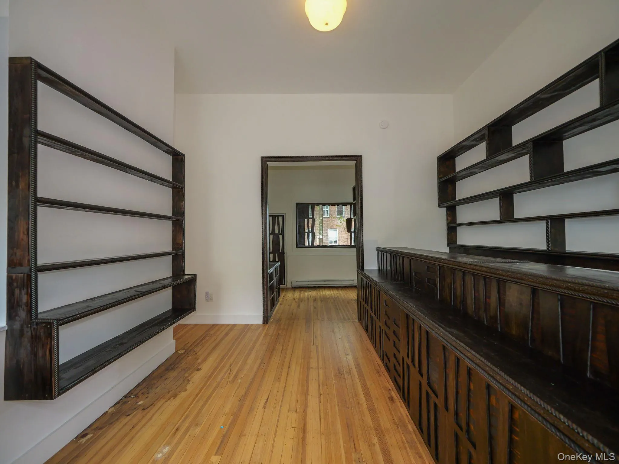 Corridor with light wood finished floors and a baseboard radiator Corridor with light wood finished floors and a baseboard radiator