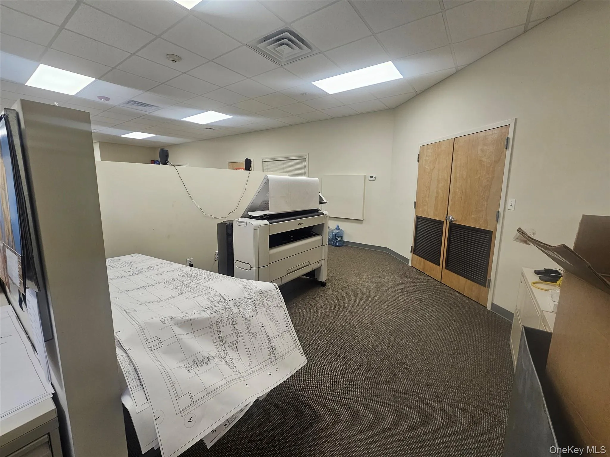 Bedroom with dark carpet, a drop ceiling, and a closet Bedroom with dark carpet, a drop ceiling, and a closet